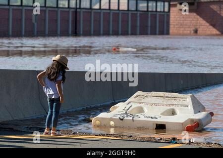 I bambini possono ammirare danni da alluvioni e detriti da una rampa chiusa dell'autostrada dopo l'uragano Ida. Foto Stock