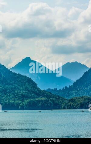 Riposatevi su un lago di montagna vicino a Neuschwanstein. La famiglia è seduta in barca Foto Stock