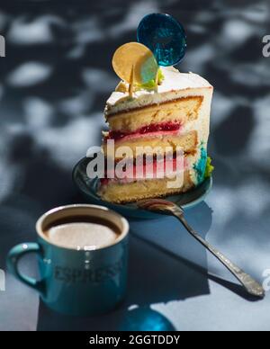 Piatto con fetta di gustosa torta fatta in casa sul tavolo, torta al lampone. Colourful lollipop swirl su bastone di legno Foto Stock