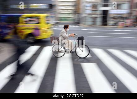 Tokio, Giappone. 03 Settembre 2021. Una donna anziana attraversa un crosswalk su una bicicletta nel quartiere Nihionbashi. Credit: Karl-Josef Hildenbrand/dpa/Alamy Live News Foto Stock