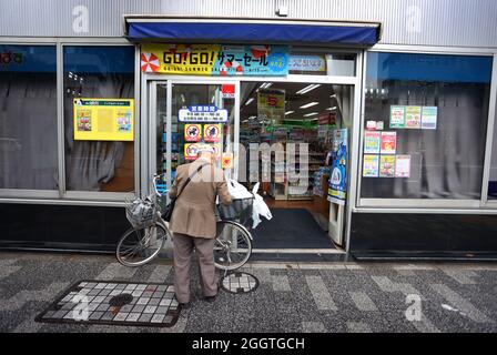 Tokio, Giappone. 03 Settembre 2021. Un uomo si alza accanto alla bicicletta fuori da un supermercato nel quartiere Nihionbashi. Credit: Karl-Josef Hildenbrand/dpa/Alamy Live News Foto Stock