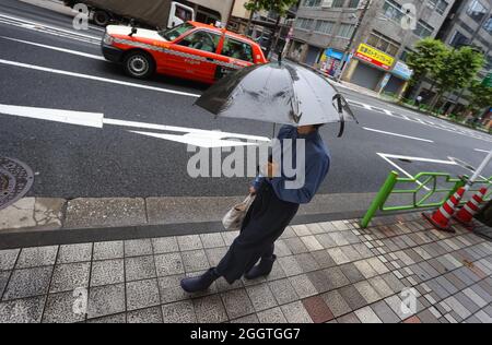 Tokio, Giappone. 03 Settembre 2021. Una donna con un ombrello cammina su un marciapiede nel quartiere Nihionbashi. Credit: Karl-Josef Hildenbrand/dpa/Alamy Live News Foto Stock