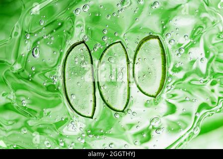 Struttura delle fette di aloe vera con gel su sfondo verde. Pianta medicinale. Disposizione piatta. Vista dall'alto. Piante naturali di erbe mediche, cura della pelle, sanità e beau Foto Stock