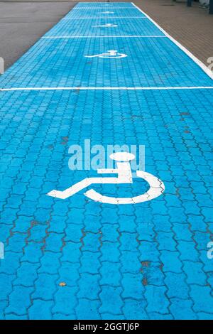 Parcheggi per disabili con marcatura dipinta di blu e bianco Foto Stock