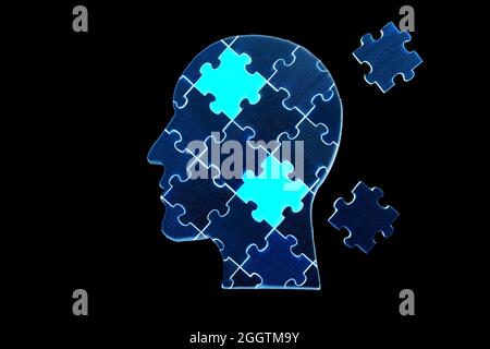 Puzzle di silhouette della testa umana con due pezzi finali da posizionare isolato su nero Foto Stock