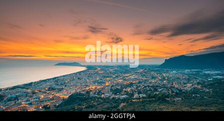 Terracina, Italia. Vista dall'alto skyline città in serata Tramonto. Illuminazioni cittadine Foto Stock