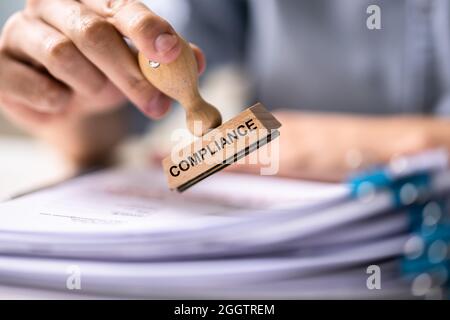 Timbro in gomma sulla conformità aziendale sul documento. Registrazione e approvazione legale Foto Stock
