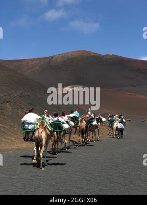 LANZAROTE, SPAGNA - 18 GENNAIO 2018: I turisti che hanno Camel giri al famoso Parco Nazionale di Timanfaya sull'isola vulcanica di Lanzarote in Spagna Foto Stock