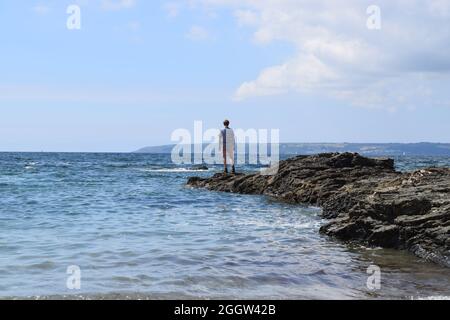 Figura sulle rocce costiere Foto Stock