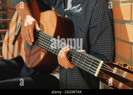 Donna in camicia che suona la chitarra classica Foto Stock