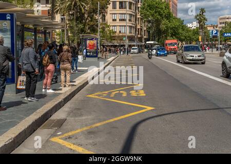 Palma di Maiorca, Spagna; aprile 23 2021: Fermata dell'autobus a Plaza de España a Palma di Maiorca. I passeggeri in attesa di indossare maschere chirurgiche facciali a causa di t Foto Stock