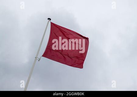 Una bandiera rossa lungo la costa olandese che indica che è vietato nuotare nell'oceano (Kijkduin, l'Aia, Paesi Bassi) Foto Stock