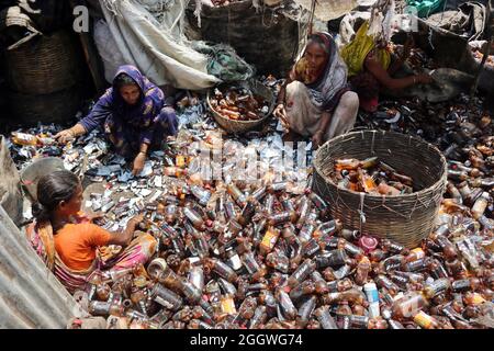 Dhaka, Bangladesh, 03/09/2021, le lavoratrici separano bottiglie di polietilene tereftalato (PET) in una fabbrica di riciclaggio alla periferia di Dhaka. Il riciclaggio delle bottiglie in plastica è diventato un'attività in crescita negli ultimi due anni e contribuisce a proteggere l'ambiente. Secondo la Bangladesh PET Flakes Manufacturers and Exporters Association (BPFMEA), il Bangladesh esporta in media quasi 30,000 tonnellate di fiocchi di bottiglie di PET principalmente in Cina, Corea del Sud e Taiwan per un valore di 14 milioni di dollari l'anno. Il 3 settembre 2021. (Foto di Habibur Rahman / Eyepix Group) Foto Stock