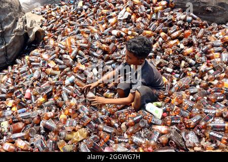 Dhaka, Bangladesh, 03/09/2021, Un bambino separa bottiglie di polietilene tereftalato (PET) in una fabbrica di riciclaggio alla periferia di Dhaka. Il riciclaggio delle bottiglie in plastica è diventato un'attività in crescita negli ultimi due anni e contribuisce a proteggere l'ambiente. Secondo la Bangladesh PET Flakes Manufacturers and Exporters Association (BPFMEA), il Bangladesh esporta in media quasi 30,000 tonnellate di fiocchi di bottiglie di PET principalmente in Cina, Corea del Sud e Taiwan per un valore di 14 milioni di dollari l'anno. Il 3 settembre 2021. (Foto di Habibur Rahman / Eyepix Group) Foto Stock