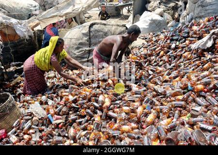 Dhaka, Bangladesh, 03/09/2021, i lavoratori separano bottiglie di polietilene tereftalato (PET) in una fabbrica di riciclaggio alla periferia di Dhaka. Il riciclaggio delle bottiglie in plastica è diventato un'attività in crescita negli ultimi due anni e contribuisce a proteggere l'ambiente. Secondo la Bangladesh PET Flakes Manufacturers and Exporters Association (BPFMEA), il Bangladesh esporta in media quasi 30,000 tonnellate di fiocchi di bottiglie di PET principalmente in Cina, Corea del Sud e Taiwan per un valore di 14 milioni di dollari l'anno. Il 3 settembre 2021. (Foto di Habibur Rahman / Eyepix Group) Foto Stock