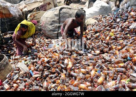 Dhaka, Bangladesh, 03/09/2021, i lavoratori separano bottiglie di polietilene tereftalato (PET) in una fabbrica di riciclaggio alla periferia di Dhaka. Il riciclaggio delle bottiglie in plastica è diventato un'attività in crescita negli ultimi due anni e contribuisce a proteggere l'ambiente. Secondo la Bangladesh PET Flakes Manufacturers and Exporters Association (BPFMEA), il Bangladesh esporta in media quasi 30,000 tonnellate di fiocchi di bottiglie di PET principalmente in Cina, Corea del Sud e Taiwan per un valore di 14 milioni di dollari l'anno. Il 3 settembre 2021. (Foto di Habibur Rahman / Eyepix Group) Foto Stock