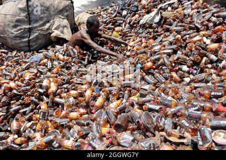 Dhaka, Bangladesh, 03/09/2021, Un uomo separa bottiglie di polietilene tereftalato (PET) in una fabbrica di riciclaggio alla periferia di Dhaka. Il riciclaggio delle bottiglie in plastica è diventato un'attività in crescita negli ultimi due anni e contribuisce a proteggere l'ambiente. Secondo la Bangladesh PET Flakes Manufacturers and Exporters Association (BPFMEA), il Bangladesh esporta in media quasi 30,000 tonnellate di fiocchi di bottiglie di PET principalmente in Cina, Corea del Sud e Taiwan per un valore di 14 milioni di dollari l'anno. Il 3 settembre 2021. (Foto di Habibur Rahman / Eyepix Group) Foto Stock