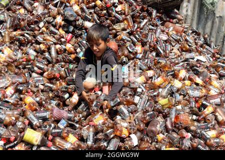 Dhaka, Bangladesh, 03/09/2021, Un bambino separa bottiglie di polietilene tereftalato (PET) in una fabbrica di riciclaggio alla periferia di Dhaka. Il riciclaggio delle bottiglie in plastica è diventato un'attività in crescita negli ultimi due anni e contribuisce a proteggere l'ambiente. Secondo la Bangladesh PET Flakes Manufacturers and Exporters Association (BPFMEA), il Bangladesh esporta in media quasi 30,000 tonnellate di fiocchi di bottiglie di PET principalmente in Cina, Corea del Sud e Taiwan per un valore di 14 milioni di dollari l'anno. Il 3 settembre 2021. (Foto di Habibur Rahman / Eyepix Group) Foto Stock