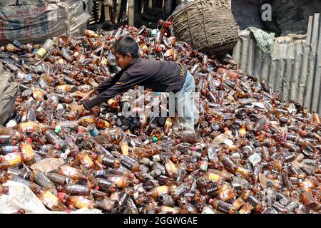 Dhaka, Bangladesh, 03/09/2021, Un bambino separa bottiglie di polietilene tereftalato (PET) in una fabbrica di riciclaggio alla periferia di Dhaka. Il riciclaggio delle bottiglie in plastica è diventato un'attività in crescita negli ultimi due anni e contribuisce a proteggere l'ambiente. Secondo la Bangladesh PET Flakes Manufacturers and Exporters Association (BPFMEA), il Bangladesh esporta in media quasi 30,000 tonnellate di fiocchi di bottiglie di PET principalmente in Cina, Corea del Sud e Taiwan per un valore di 14 milioni di dollari l'anno. Il 3 settembre 2021. (Foto di Habibur Rahman / Eyepix Group) Foto Stock