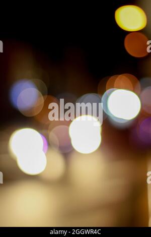 fuori fuoco bello scintillante bokeh sfocato di automobili e semafori di notte. Traffico cittadino sfocato sulla strada della città. Luce colorata sfocata Foto Stock