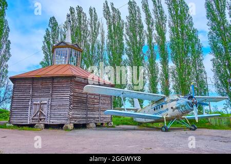 PEREIASLAV, UCRAINA - 22 MAGGIO 2021: L'aereo sovietico vintage vicino alla cappella del legno a Pereiaslav Scansen, il 22 maggio a Pereiaslav Foto Stock