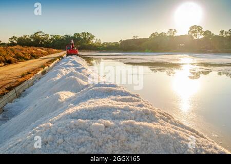 Un cumulo di cristalli di sale vicino ad un laghetto pieno di sale dopo evaporazione dell'acqua dell'oceano a salines a Faro, Algarve, Portogallo Foto Stock