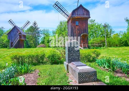 PEREIASLAV, UCRAINA - 22 MAGGIO 2021: Il monumento in pietra, decorato con Menorah sul luogo dell'ex cimitero ebraico di fronte a mulini a vento in legno Foto Stock