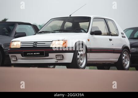 Cobreces, Spagna - 14 agosto 2021: Mostra auto a Cobreces. Peugeot 205 GTI bianco originale. La Peugeot 205 è un'auto prodotta dal costruttore francese Foto Stock