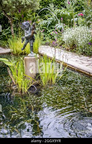 Statua e fontana nel laghetto giardino Foto Stock