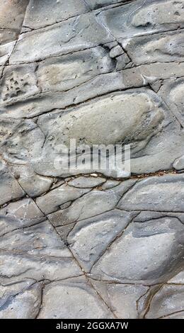 Texture in pietra grigia naturale e sfondo carta da parati, una grande roccia con segni naturali di erosione. Foto Stock