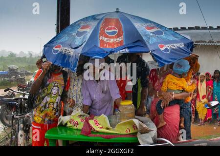 Purulia, Bengala Occidentale, India - Lunedì 14th Agosto 2017 : Moody immagine di monsone, gente rurale si rifugiò sotto il cofano per sfuggire alla pioggia. Stagione piovosa. Foto Stock