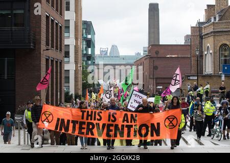 Londra, Regno Unito. 2 settembre 2021. Estinzione gli attivisti climatici della ribellione attraversano il Millennium Bridge dalla Tate Modern fino a raggiungere la City di Londra l'undicesimo giorno delle loro impossibili proteste di ribellione. Più di 50 attivisti indossavano dei cartelli che indicavano di infrangere le condizioni restrittive della cauzione entrando nella città di Londra. Estinzione la ribellione sta chiedendo al governo britannico di cessare tutti i nuovi investimenti di combustibili fossili con effetto immediato. Credit: Mark Kerrison/Alamy Live News Foto Stock