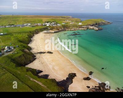 Vista aerea dal drone della spiaggia del villaggio e del porto a Port Ness, all'estremità settentrionale dell'isola di Lewis, Ebridi esterne, Scozia, Regno Unito Foto Stock