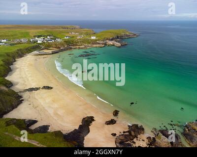 Vista aerea dal drone della spiaggia del villaggio e del porto a Port Ness, all'estremità settentrionale dell'isola di Lewis, Ebridi esterne, Scozia, Regno Unito Foto Stock