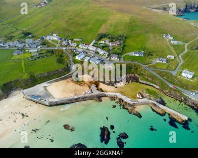 Vista aerea dal drone del villaggio e del porto a Port Ness all'estremità settentrionale dell'isola di Lewis, Ebridi esterne, Scozia, Regno Unito Foto Stock