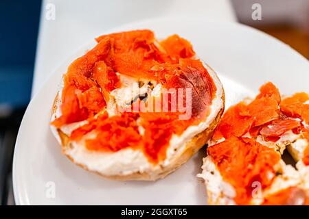 Pane tradizionale bagel fette tostate lox closeup su piatto bianco con formaggio cremoso e salmone affumicato sockeye come cibo per il brunch della colazione Foto Stock