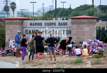 Oceanside, California, Stati Uniti. 31 ago 2021. Nove Marines e un marinaio con base a Camp Pendleton sono stati tra i 13 membri del servizio degli Stati Uniti uccisi nell'attacco aeroportuale di Kabul. Quattro di quelli uccisi erano residenti della California. L'attacco unico più letale contro le forze americane in Afghanistan in 10 anni. Amici e familiari si riunirono per lasciare i fiori e onorarli. Credit: Katrina Kochneva/ZUMA Wire/Alamy Live News Foto Stock