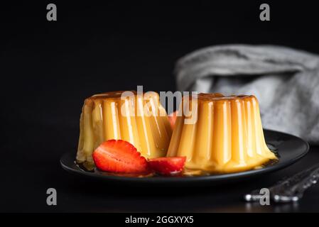 budino di vanila fatto in casa a forma di stampo servito su un piatto. Gustoso dessert al latte Foto Stock