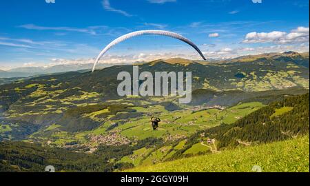 Parapendio volare sulle montagne nel giorno di estate Foto Stock