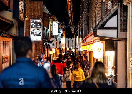 Kyoto, Giappone - 16 aprile 2019: Persone affollate a piedi lungo la stretta strada del quartiere di Pontocho vicolo di notte da izakaya ristoranti insegne in serata buia Foto Stock