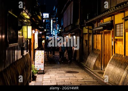 Kyoto, Giappone - 16 aprile 2019: Vicolo stretto nel quartiere di Gion di notte con gente e illuminato edificio ristorante con menu Foto Stock