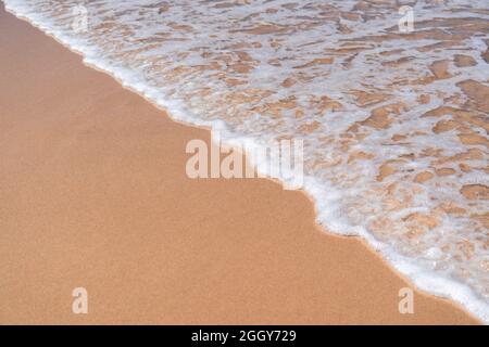 Schiuma di mare su sabbia texture sfondo vista dall'alto nessuna gente. Ocean Waves sulla spiaggia di sabbia bagnata concetto di vacanza Foto Stock