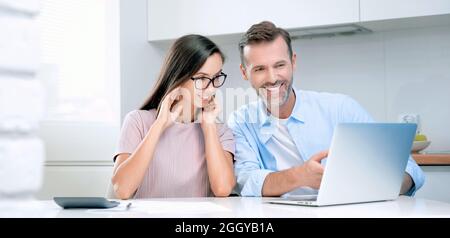 Giovane coppia che calcola i soldi a casa. Revisione finanziaria, concetto domestico di preventivo Foto Stock