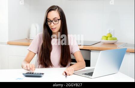 Donna che lavora con la calcolatrice. Contabilità, concetto di finanze domestiche Foto Stock