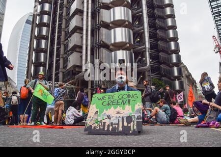 Londra, Regno Unito. 03 Settembre 2021. Un manifestante che indossa un costume si siede in viaggio con un "We're going Green!" Cartello durante la dimostrazione al di fuori del Lloyd's di Londra. I manifestanti di estinzione della ribellione hanno marciato nella città di Londra come parte della loro campagna di due settimane contro la ribellione impossibile, chiedendo al governo britannico di agire in modo significativo sulla crisi climatica ed ecologica. (Foto di Vuk Valcic/SOPA Images/Sipa USA) Credit: Sipa USA/Alamy Live News Foto Stock