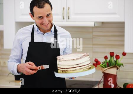 Chef pasticceria di fronte a un banco. Dolci da cucina a casa. L'armeno si dedicò alla pasticceria. Foto Stock