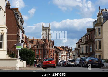 Una scena di strada a Cromer con la torre della chiesa in lontananza. Foto Stock