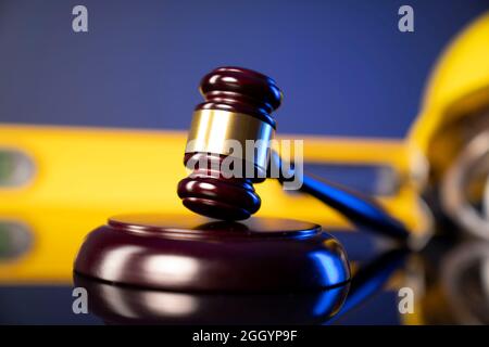 Concetto di legge di costruzione. Casco e Gavel del giudice su sfondo grigio. Foto Stock