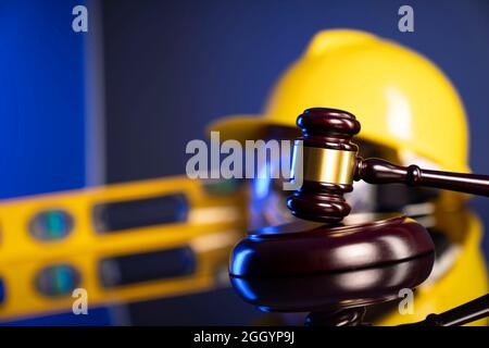 Concetto di legge di costruzione. Casco e Gavel del giudice su sfondo grigio. Foto Stock