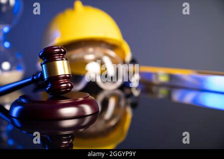 Concetto di legge di costruzione. Casco e Gavel del giudice su sfondo grigio. Foto Stock